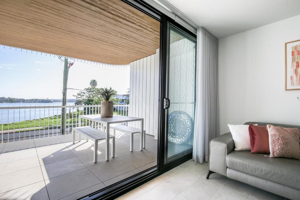 a living room with a couch and a table at Bayfront Holiday Retreat with Parking in Batemans Bay
