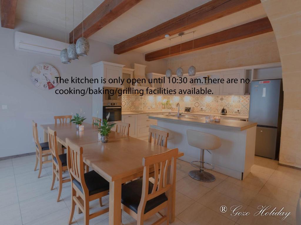 una cucina con tavolo e sedie in una stanza di Hollies a Qala