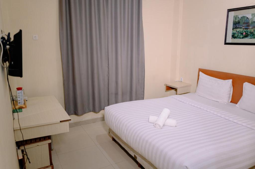 Postel nebo postele na pokoji v ubytování Kartika Sriwijaya Hotel
