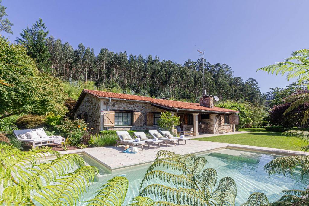 a house with a swimming pool in the yard at Elysian Villa in Miño