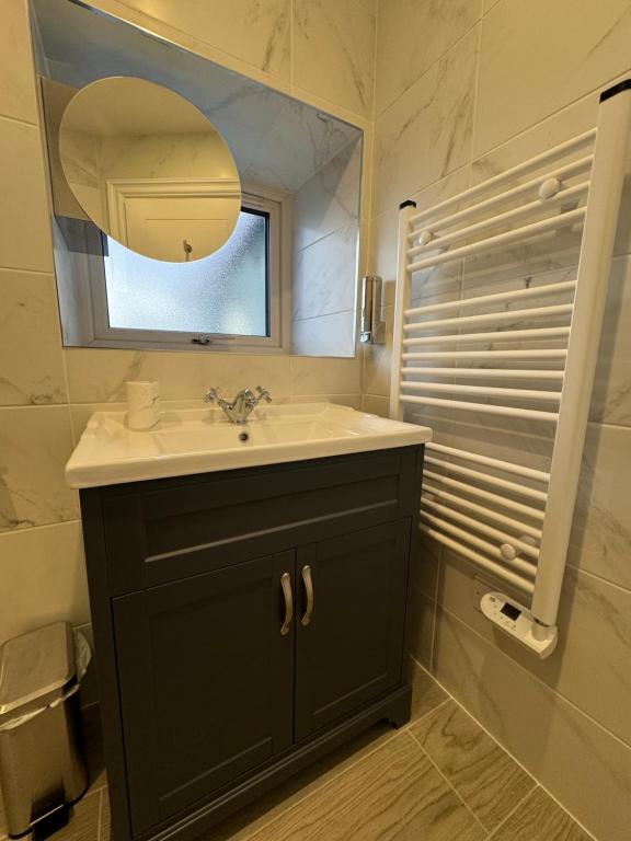 un bagno con lavandino e specchio di Krugers Guest House a Dunquin