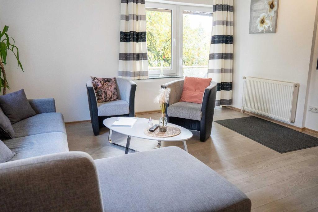 sala de estar con sofás, mesa y ventana en Villa Nordhang - Apartment 4, en Winterberg