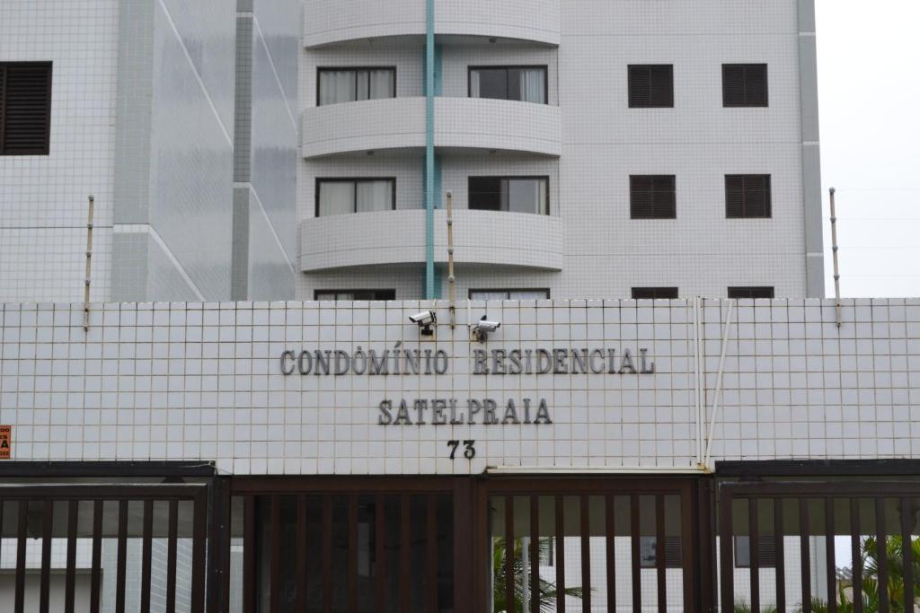 un edificio con una señal frente a un edificio en Apartamento Satel Praia, en Itanhaém