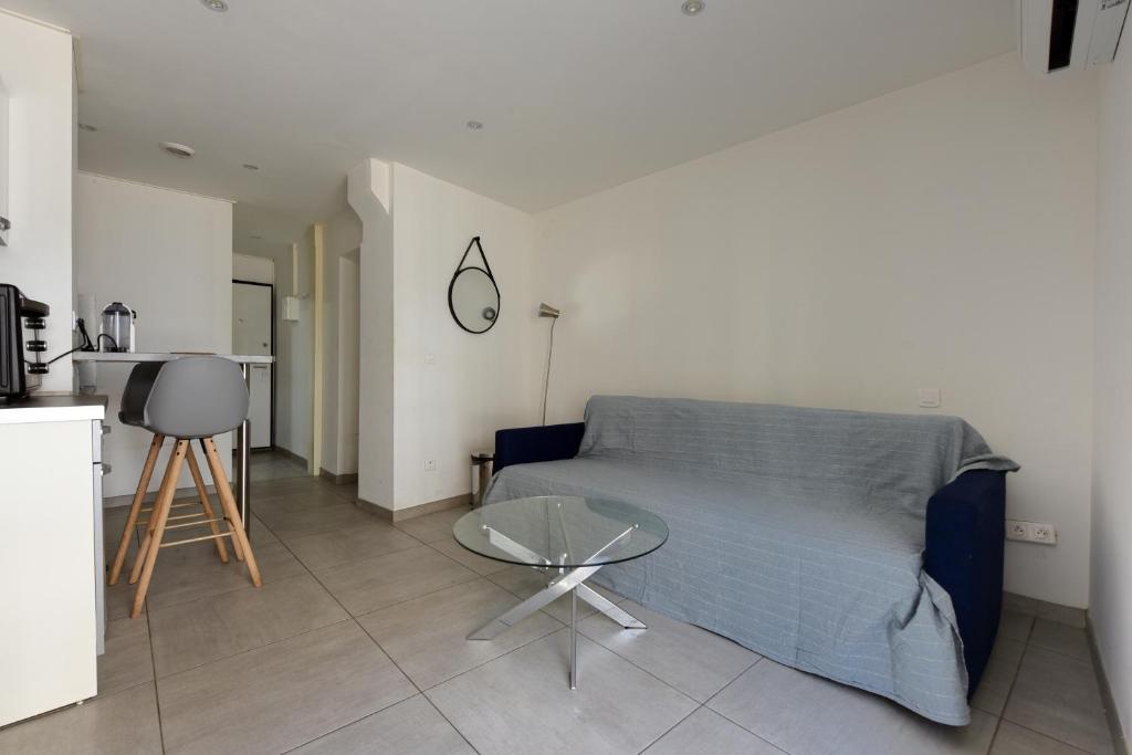 - un salon avec un lit bleu et une table dans l'établissement Provençal Studio Netflix Appart-hotel-Provence, à La Fare-les-Oliviers