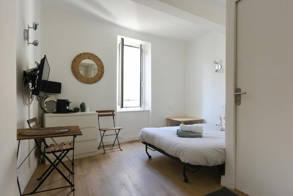 une chambre avec un lit, un bureau et une fenêtre dans l'établissement Studio Garrigue, à La Fare-les-Oliviers