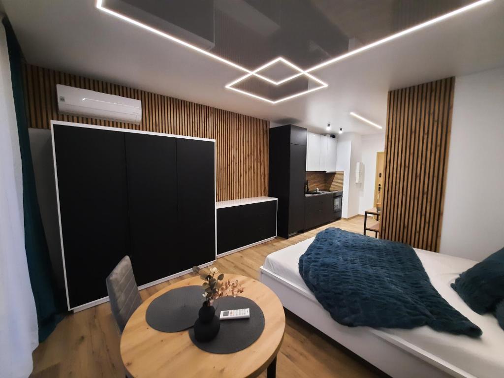 a bedroom with a bed and a table and a tv at LOCUS SKY TOWER Katowice in Katowice