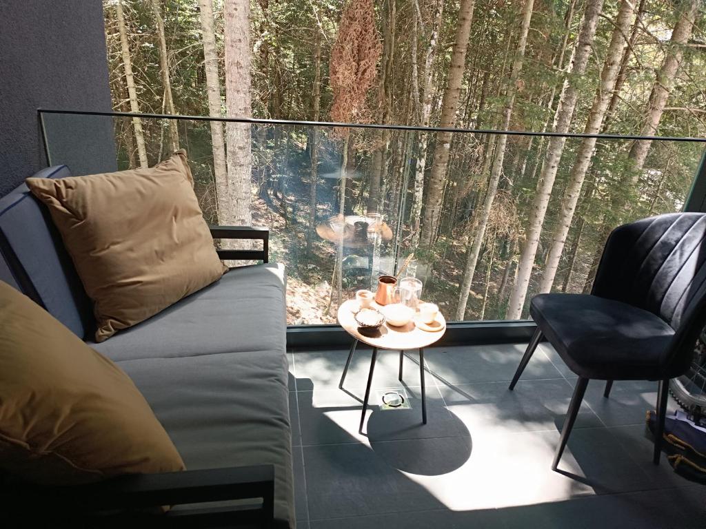 a room with a couch and a table in front of a window at Oaza in Sarajevo