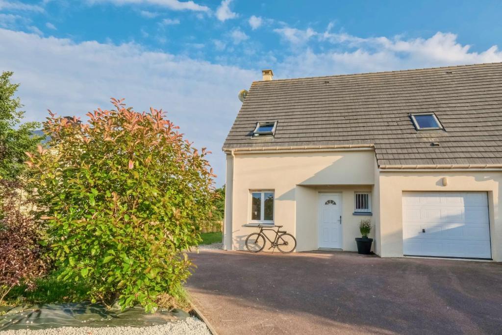 une maison avec un vélo garé à côté d'un garage dans l'établissement L'Oyat, à Barneville-Carteret