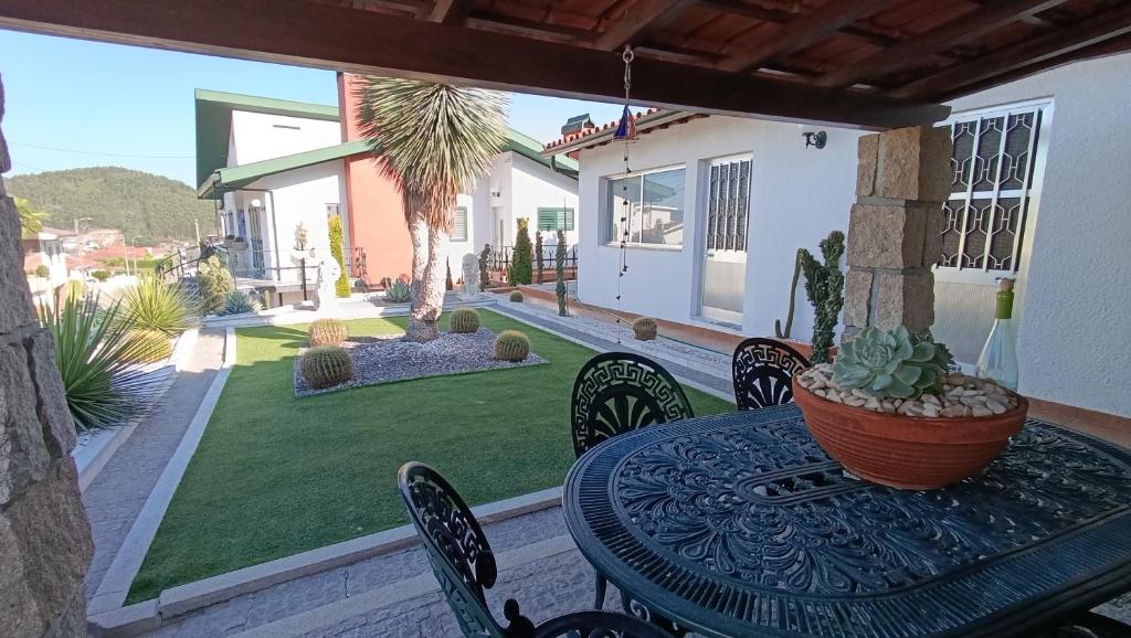 a patio with a table and chairs and a yard at Orion Guest Villa Casais in Lousada