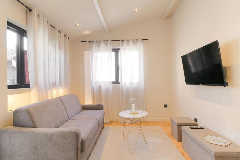 un salon avec un canapé et une télévision à écran plat dans l'établissement Appartement lumineux pour 4, Villeurbanne Cusset, à Villeurbanne