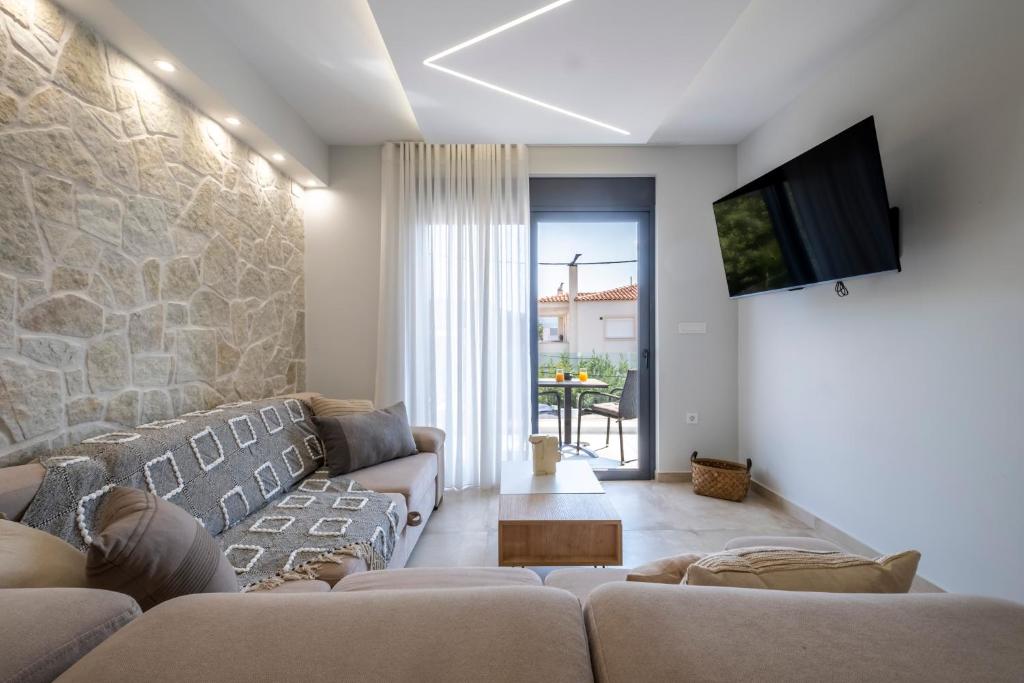 a living room with a couch and a tv at Orion Luxury Apartments in Nafplio