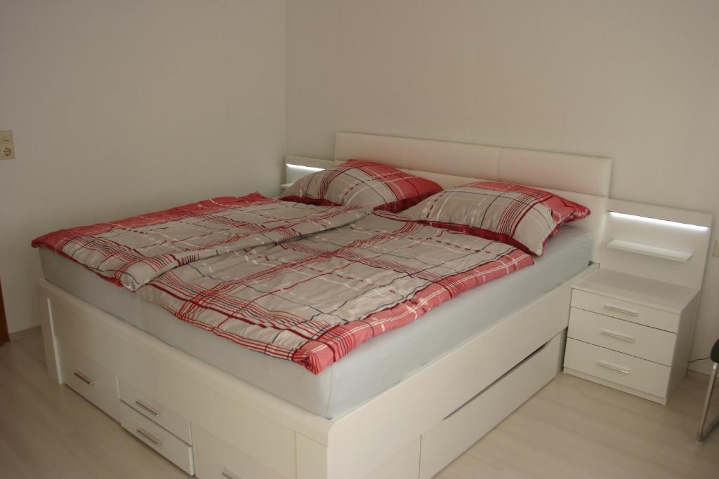 a white bed with two pillows on top of it at ApartmentBuyMetzingen in Riederich