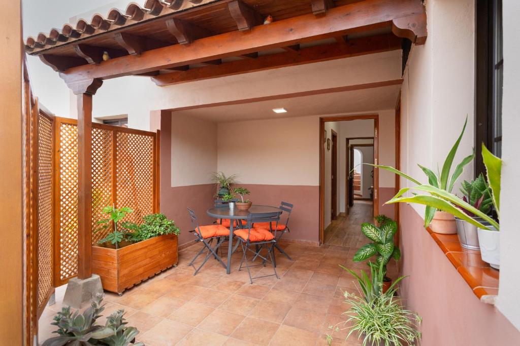 a patio with a table and chairs and plants at Casa en El Campo in Tacoronte
