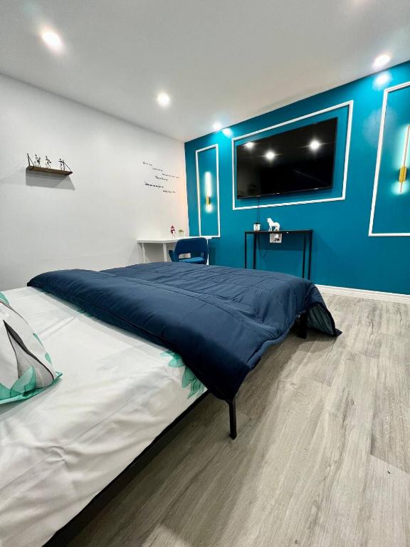 a bedroom with a large bed with a blue wall at Private Room Near Airport K8 in Mississauga