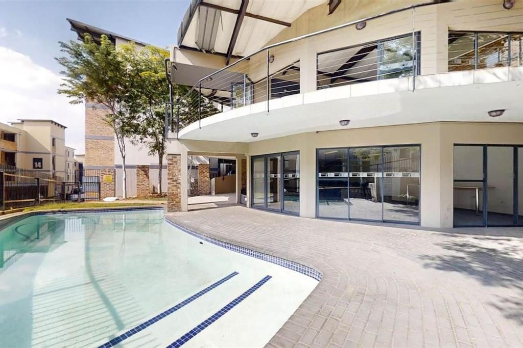 a swimming pool in front of a building at Kayalako at Solheim - fully furnished apartment in Germiston