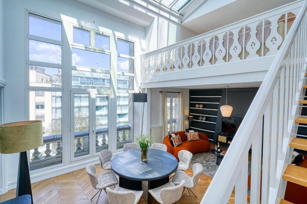 un salon avec une table et des chaises dans l'établissement Sweett - Maison Wagram, à Paris