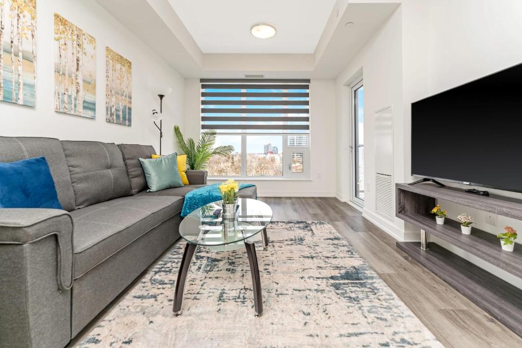 a living room with a couch and a tv at Luxury 1BR King Bed Unit - Private Balcony in Kitchener