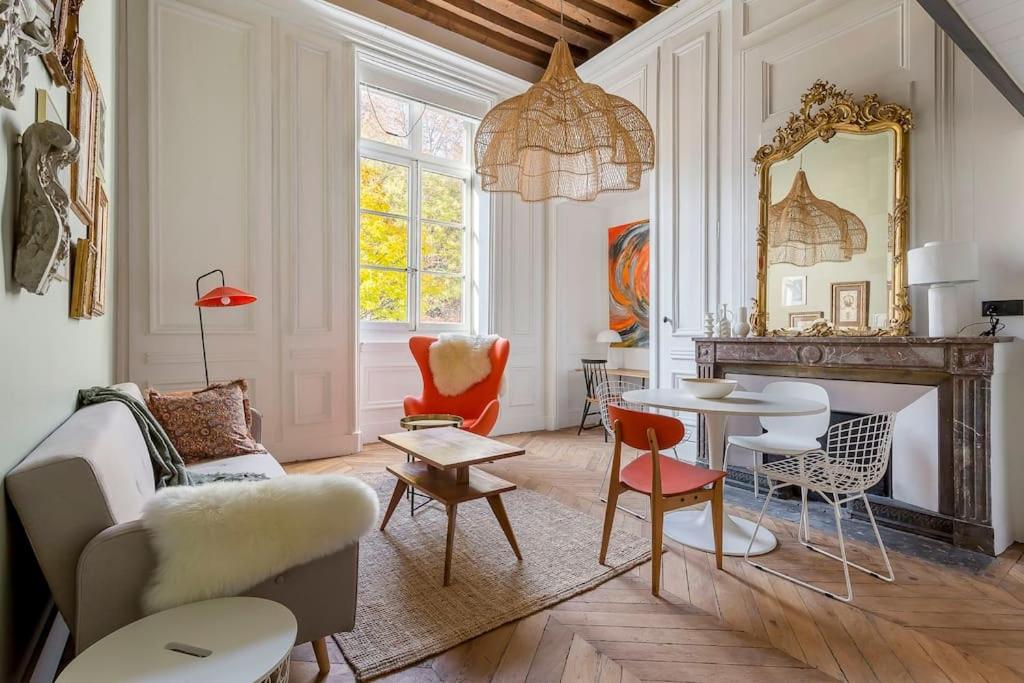 un salon avec une table et des chaises dans l'établissement L'Eugénie, secteur Opéra et climatisé, Lyon 1er, à Lyon