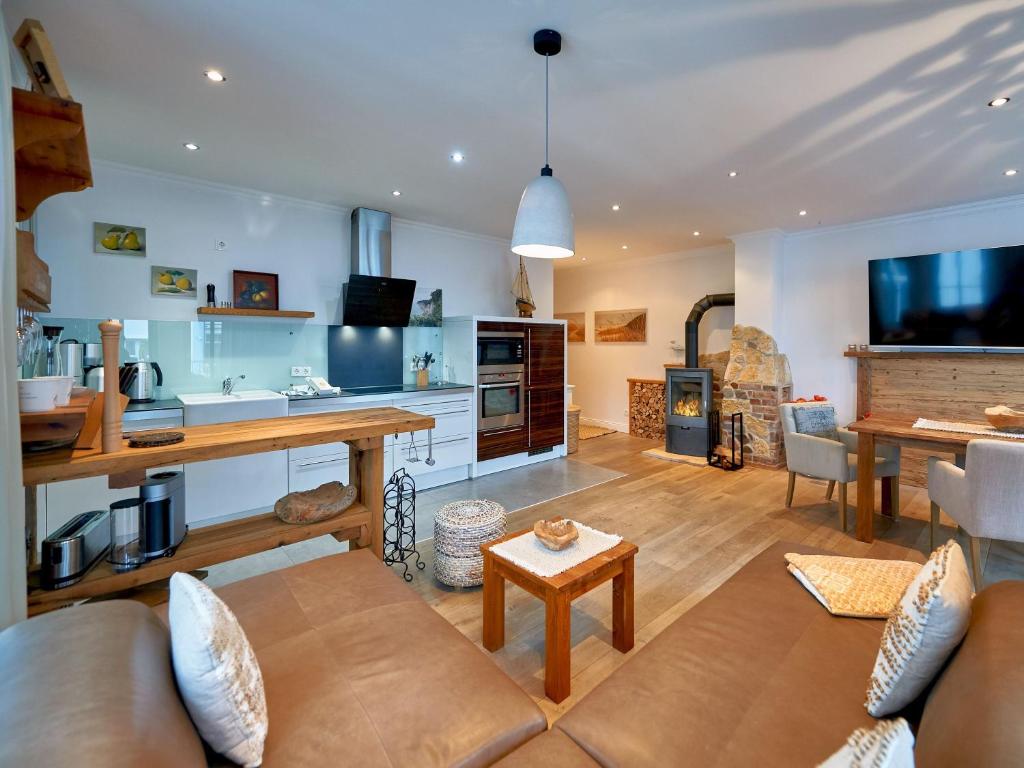 a living room with a couch and a table at Villa Paula in Sellin - WG01 "Findling" strandnah mit Kamin, Terrasse, Balkon in Ostseebad Sellin