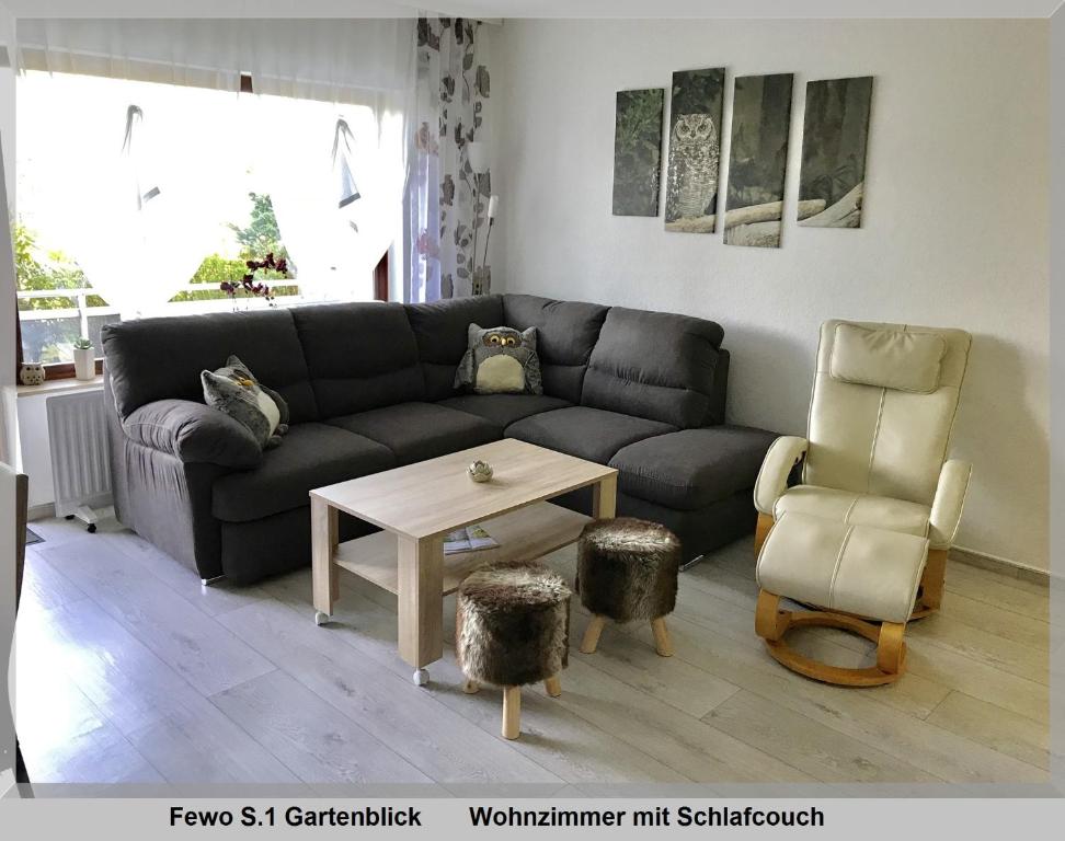 a living room with a couch and a table and a chair at Harz Fewo Eulennestchen S1 in Altenau
