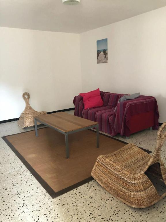 a living room with a couch and a table at Appartement moderne avec jardin à Coggia - 90m² - Vue magnifique in Coggia