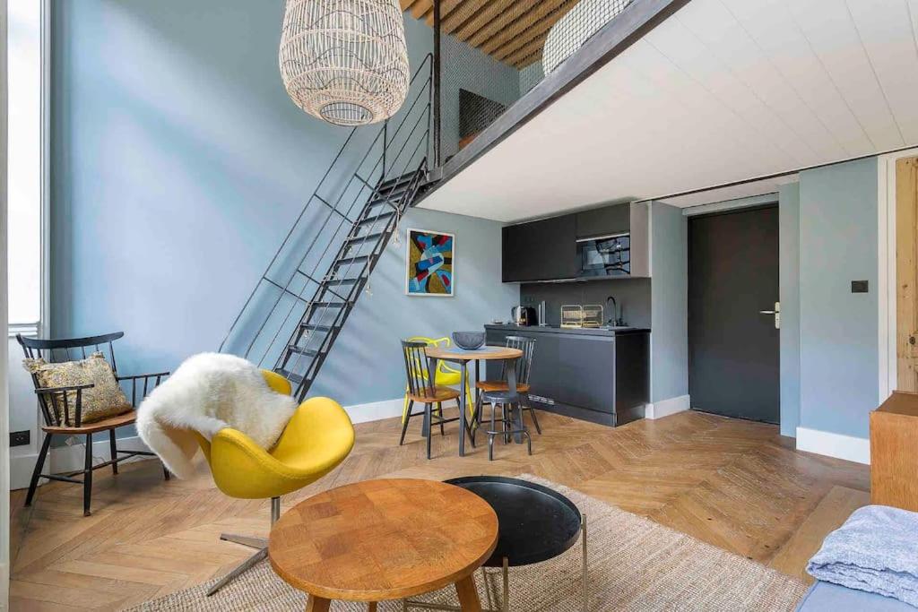 un salon avec une chaise jaune et une table dans l'établissement L'Auguste, proche Opéra et climatisé, Lyon 1, à Lyon