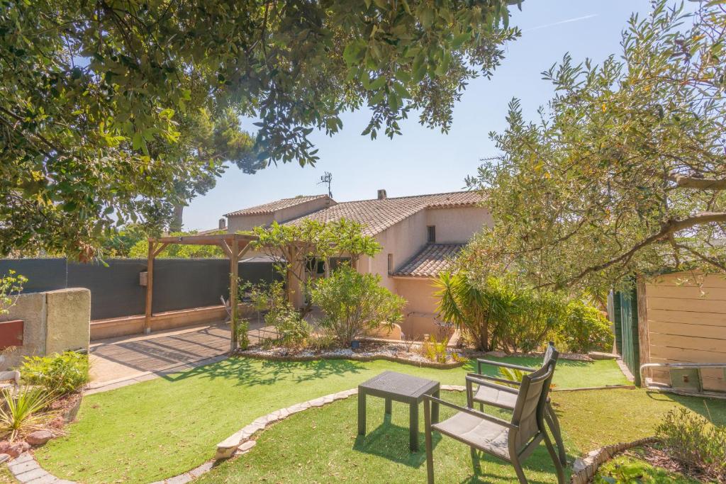 une cour avec une table et un banc dans l'établissement Appartement Pinède Romane Fréjus, à Fréjus