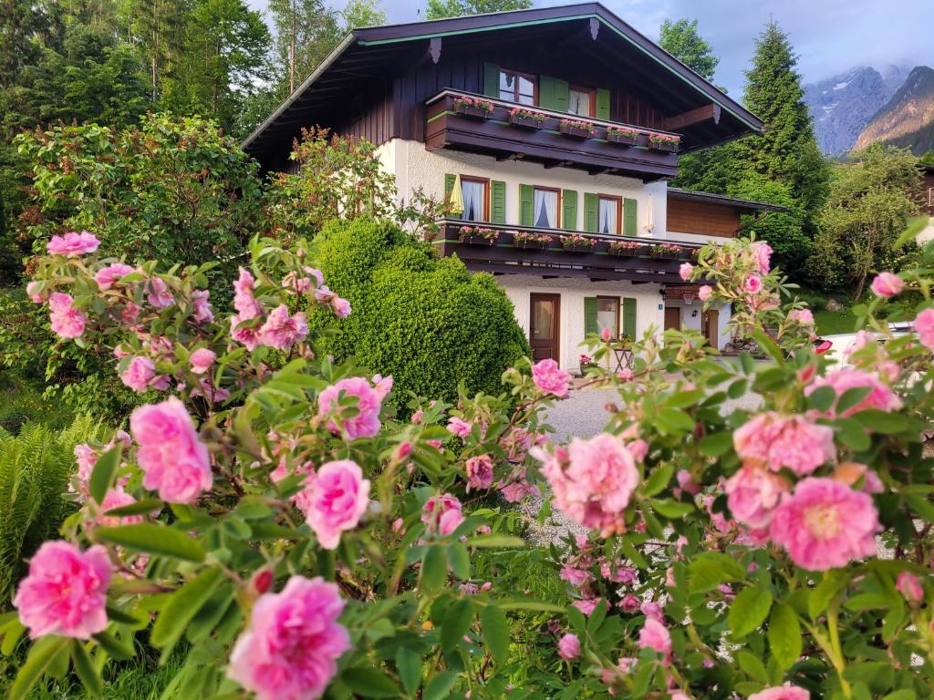 a house with pink flowers in front of it at Ferienwohnung Haus Rosenbichl GbR in Schönau am Königssee