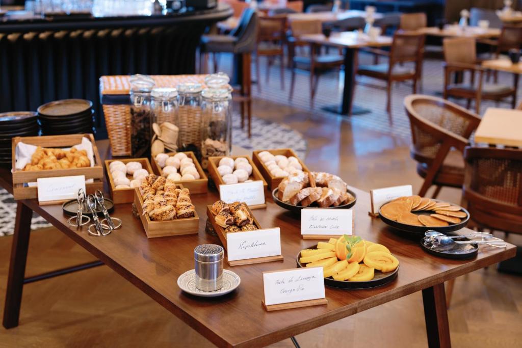 A self-service table of breads, pastries, spreads and fruit in the dining room.
