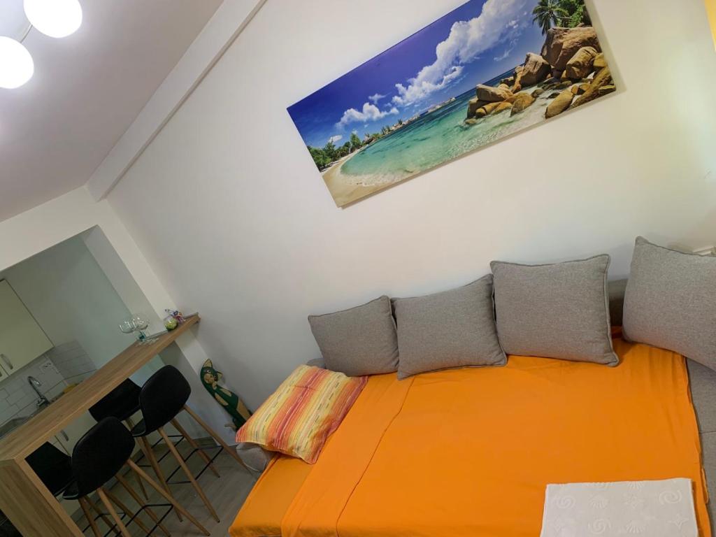 a bedroom with an orange bed with two pillows at Kućica Bojana in Budva