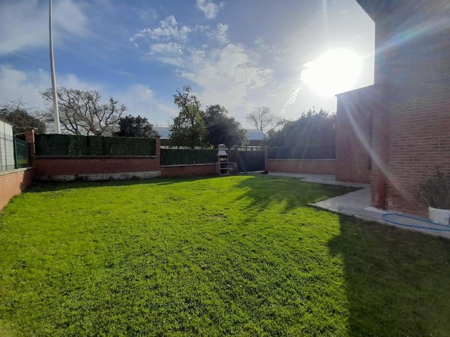 une cour arrière avec une pelouse et le soleil qui brille dans l'établissement Casa completa Loredo Beach, à Loredo