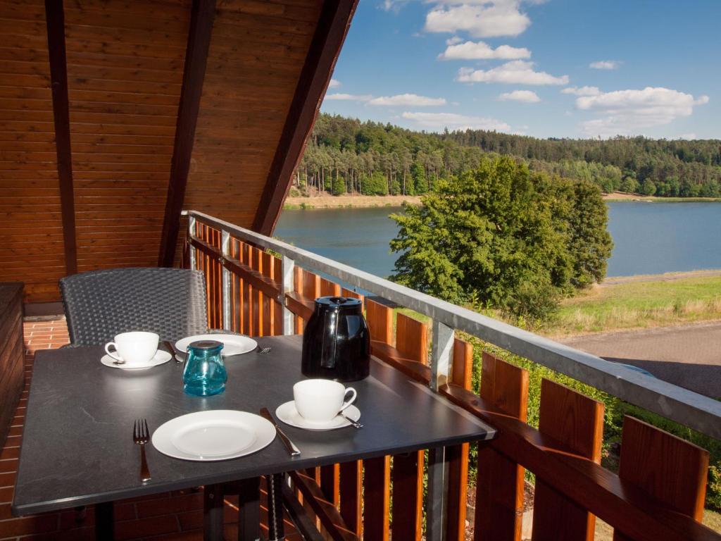 a table on a balcony with a view of a lake at FeWo Hoppenhof 2 in Bad Arolsen