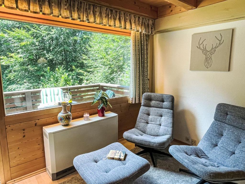 een woonkamer met twee stoelen en een groot raam bij Apartment Fliederweg by Interhome in Siegsdorf