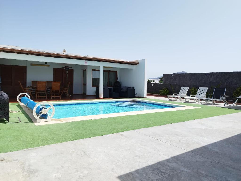 a swimming pool with a slide next to a house at CASA MONTES in Playa Blanca