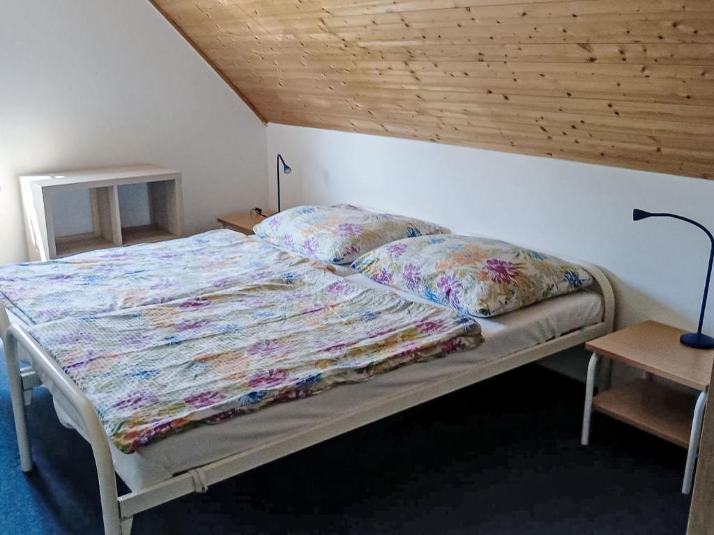 Łóżko w sypialni z drewnianym sufitem w obiekcie Holiday Home Holiday Hill 44 by Interhome w mieście Lauterwasser