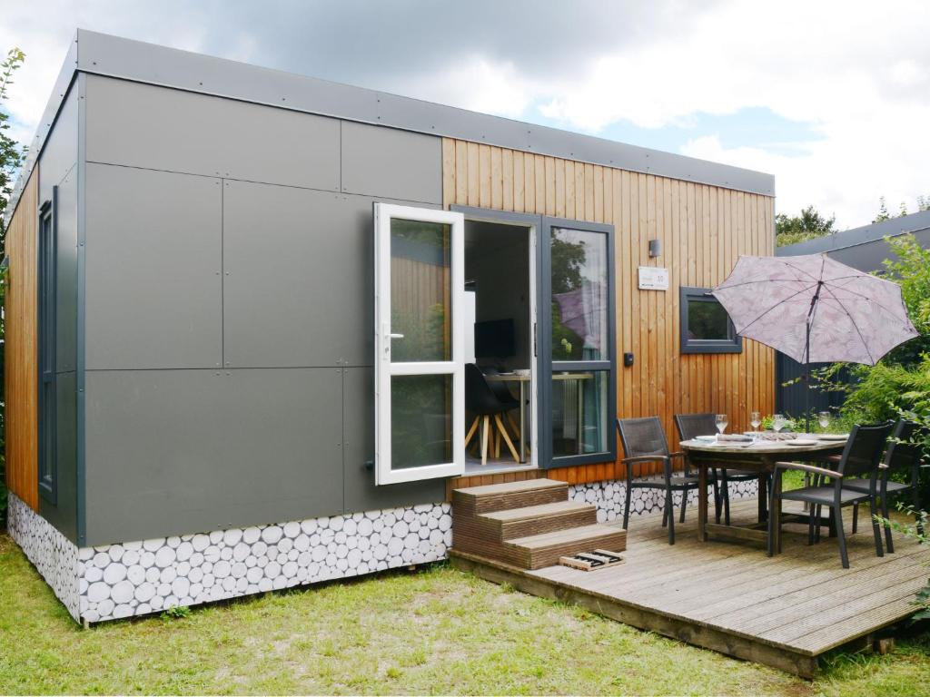 バイルングリースにあるHoliday Home Tiny Haus Kiwi by Interhomeの小屋(テーブル、傘付)