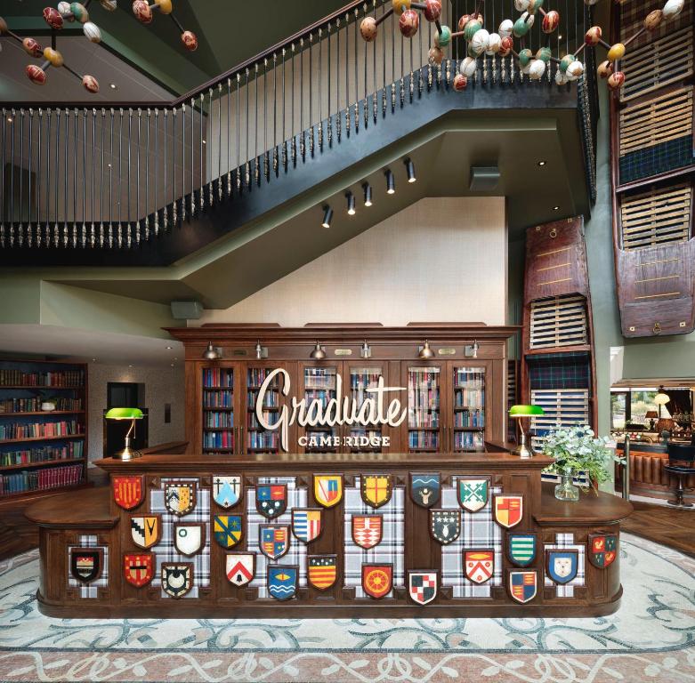 a lobby of a restaurant with a counter with a sign at Graduate by Hilton Cambridge in Cambridge