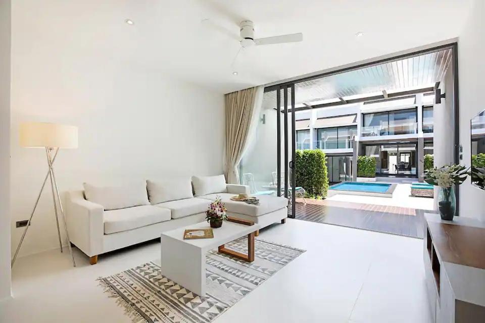 Una sala de estar con un sofá blanco y una mesa. en SUNWAY 2BD Modern Townhouse, en Koh Samui 