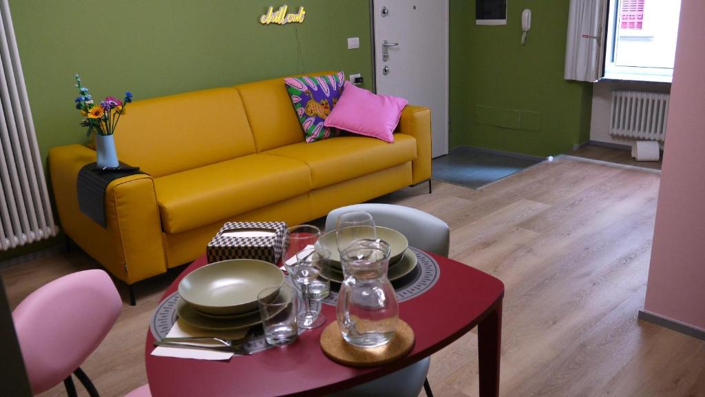 a living room with a yellow couch and a table at Pop House - Monza Park in Villasanta