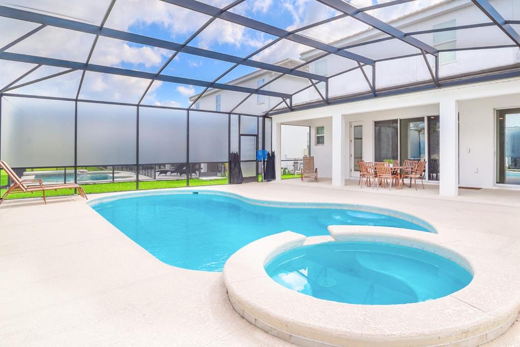 einen Pool in einem Haus mit Glasdach in der Unterkunft Family-Friendly Mansion at Sonoma Luxury Resort in Kissimmee