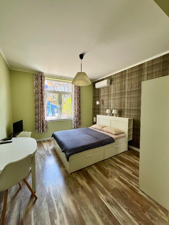 a bedroom with a bed and a desk and a table at Студио Top City Center in Plovdiv