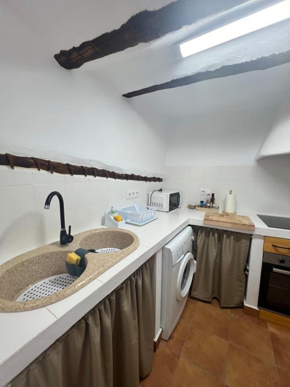 a kitchen with two sinks and a washing machine at Casa Rural Caballeriza in Hinojares