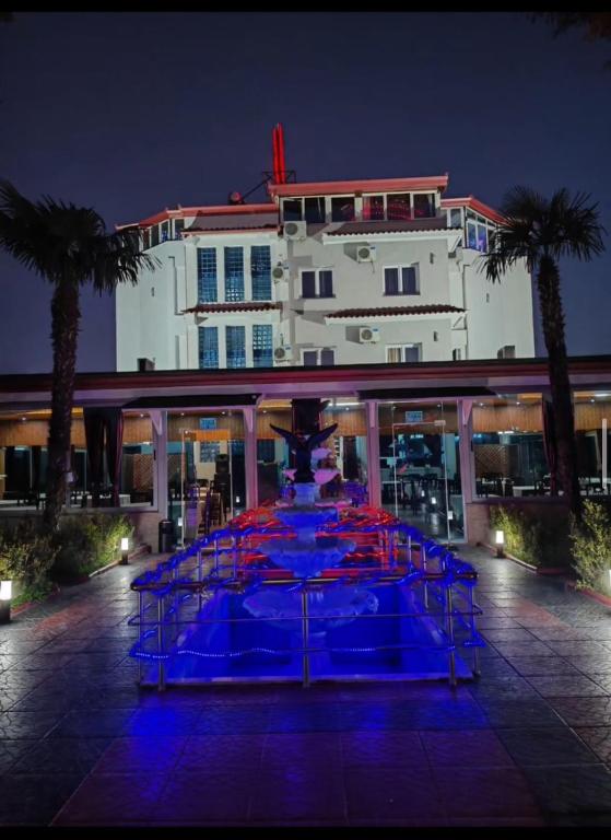 a large building with a table in front of it at Hotel Bardhi in Kuçovë