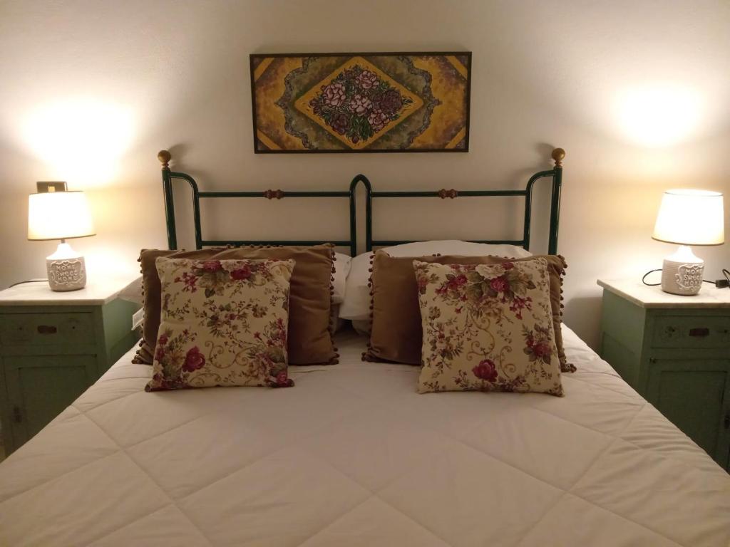 a bedroom with a bed with pillows and two lamps at Mameli Suite in Spoleto