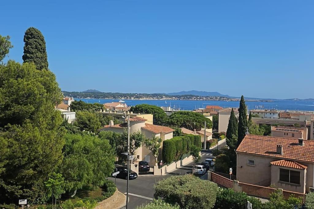 una città con una strada, alberi e l'acqua di Petit Paradis à Bandol t4 piscine clim Parking Fibre Coffre-fort a Bandol