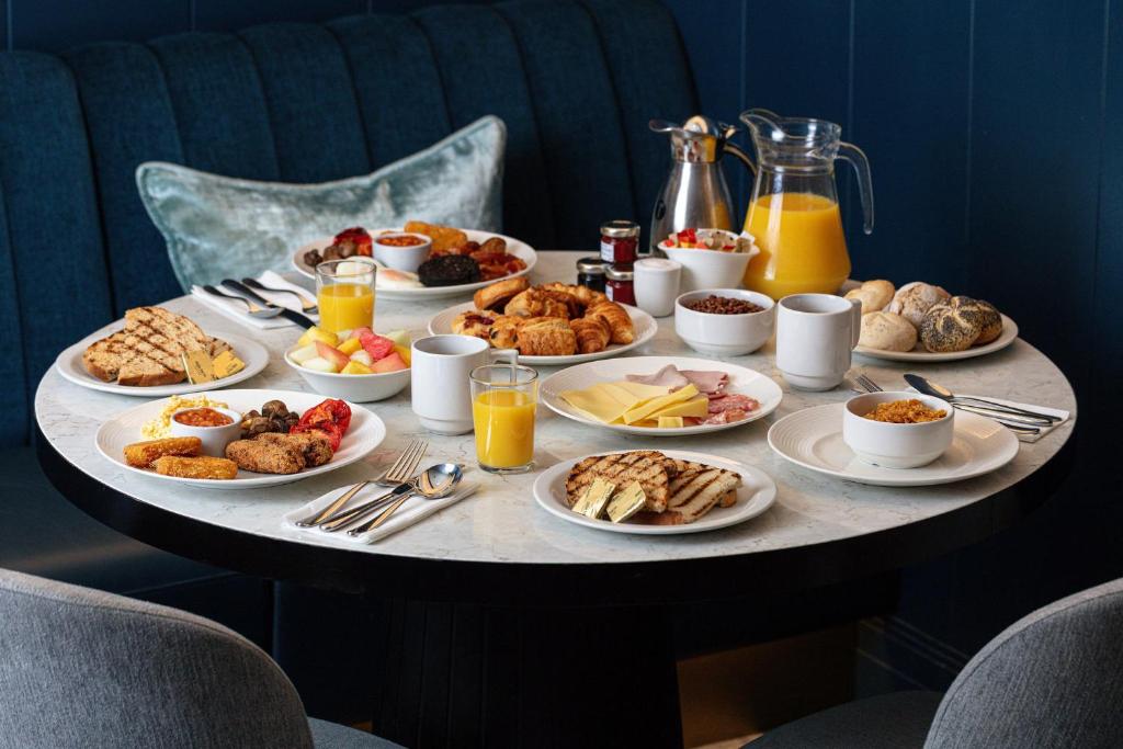 a table with plates of breakfast foods on it at Strand Palace in London