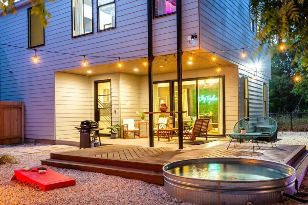 a patio with a hot tub in front of a house at Two-House Private 10BR Compound - DT 6 Min Drive in Austin