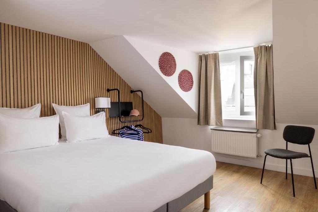 a bedroom with a large white bed and a window at Korner Opera in Paris