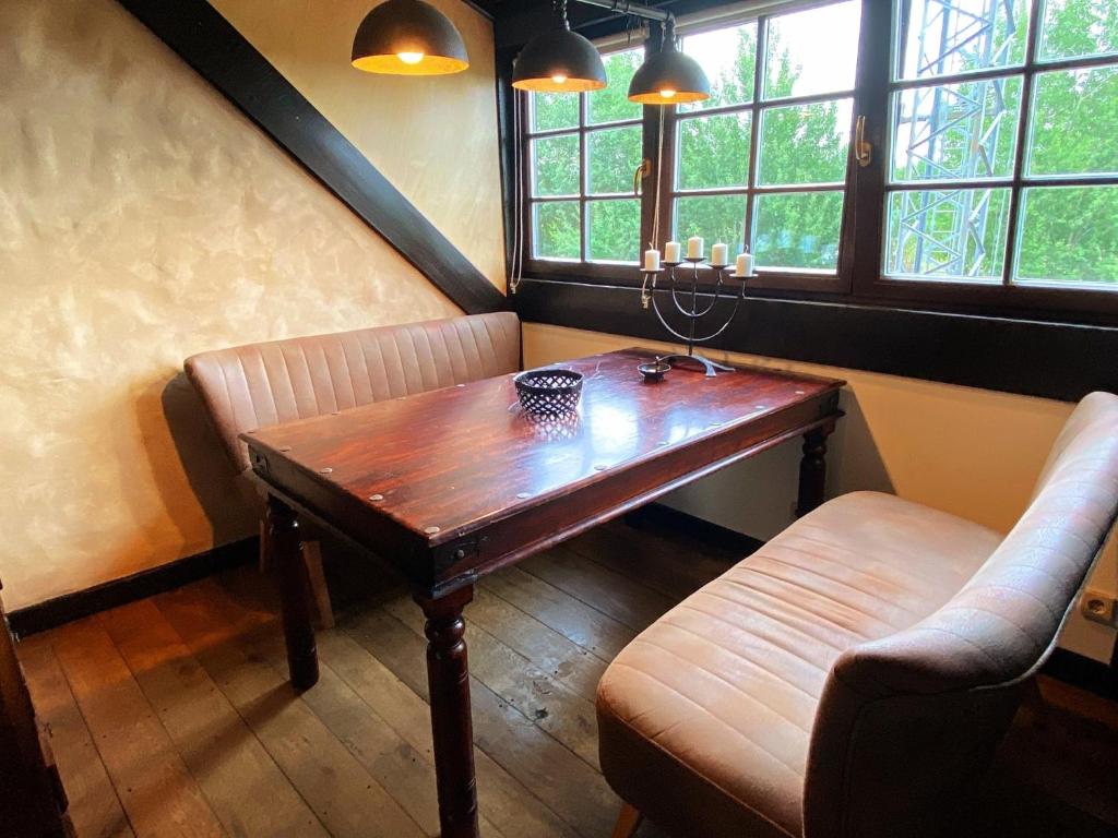 a dining room with a wooden table and two chairs at Ferienwohnung TURMZIMMER im Rittergut Leppersdorf bei Radeberg in Wachau