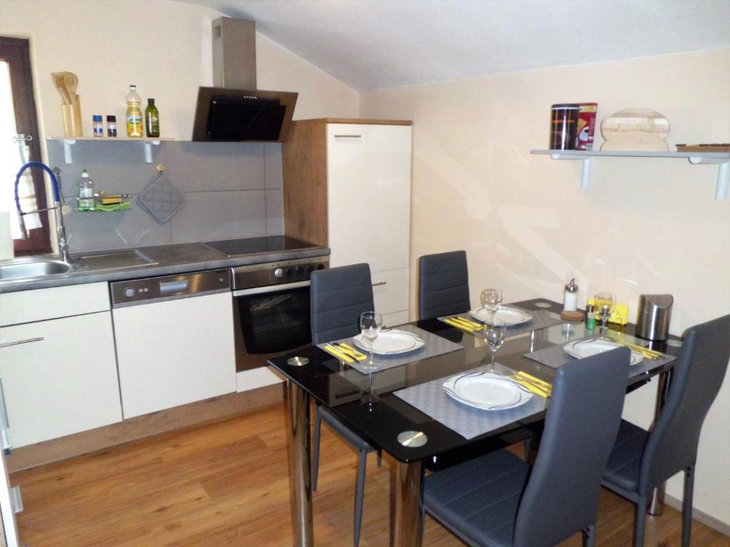 a dining room table with chairs and a kitchen at Haus Marina Apartment Bergkristall mit Gratis Eintritt Alpentherme in Bad Hofgastein